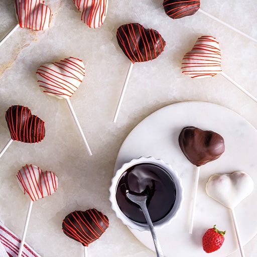 Chocolate Covered Strawberry Heart Pops with chocolate sauce in a cup