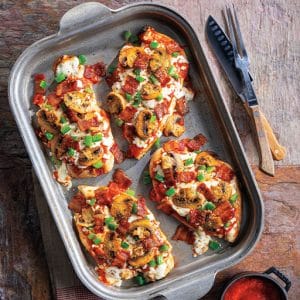 Four slices of chicken breast pizza are arranged on a pan, showcasing a variety of toppings and melted cheese.