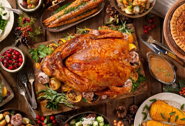 A cooked turkey with side dishes kept on a dining table for a family holiday dinner